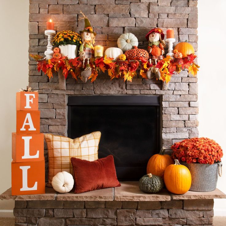 a fireplace decorated with fall decorations and pumpkins