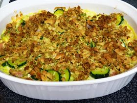 a casserole dish with zucchini, sausage and bread crumbs