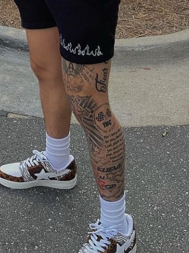 a man with tattoos on his leg and foot