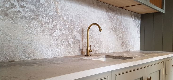 a kitchen counter with a sink and faucet on it, next to cabinets