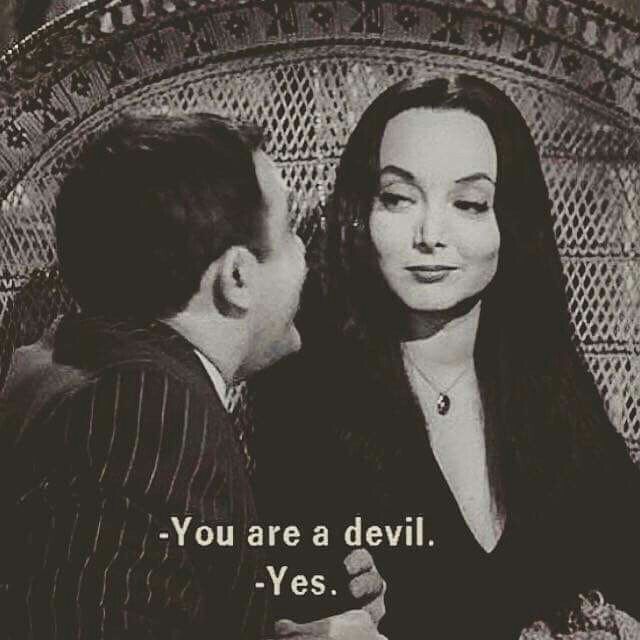 a man and woman sitting next to each other in front of a screen with the words you are a devil yes