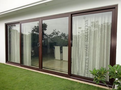 an outside view of a house with sliding glass doors and green grass on the lawn