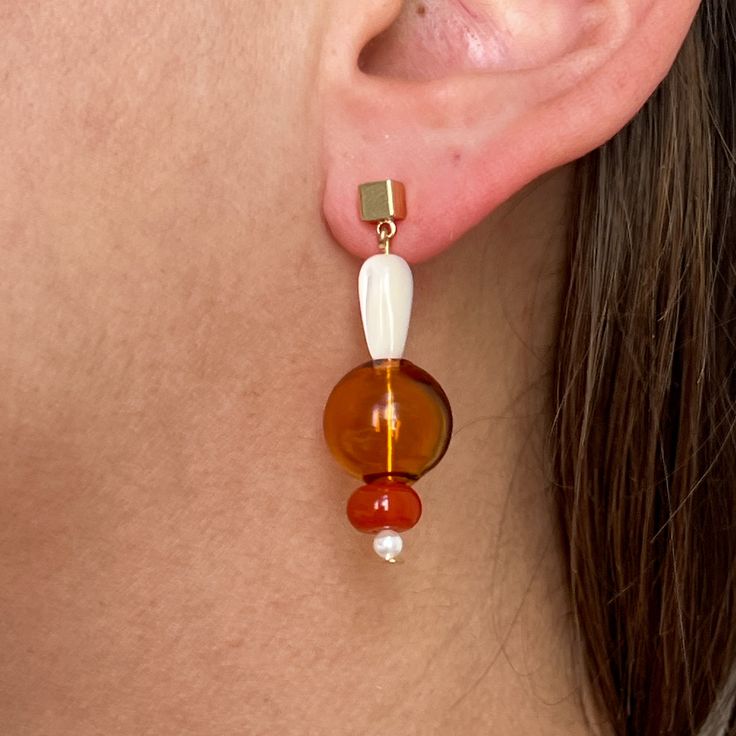 Featuring a combination of glass beading and natural stones, these contemporary earrings bring a hint of luxury to any ensemble. Made with neutral colors that complement any wardrobe, these earrings are the ultimate statement of refinement and elegance. Modern Brown Jewelry For Parties, Elegant Glass Drop Earrings, Elegant Glass Dangle Jewelry, Elegant Dangle Glass Jewelry, Elegant Amber Round Bead Earrings, Chic Brown Dangle Jewelry, Elegant Dangling Beads Earrings, Trendy Beige Drop Earrings, Elegant Czech Glass Jewelry With Matching Earrings