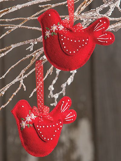 two red bird ornaments hanging from a tree