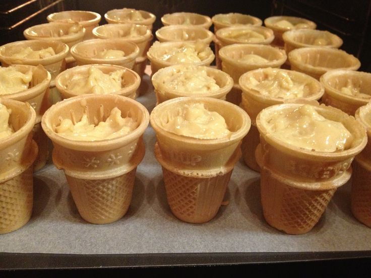 there are many ice cream cones lined up on the counter top and ready to be eaten