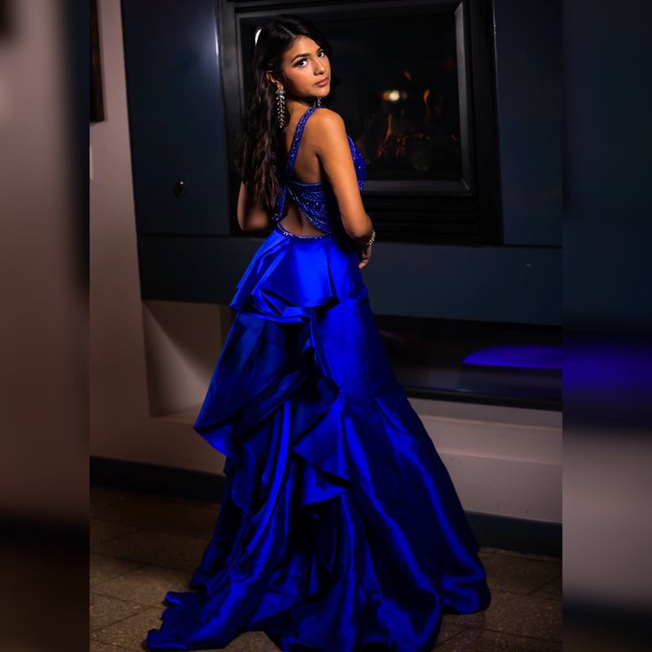 Royal Blue formal gown with ruffled back detail and tulle.  Top of dress has royal blue and silver beading detail and cross back. Glamorous Blue Ball Gown For Prom, Glamorous Blue Ruffled Evening Dress, Glamorous Blue Evening Dress With Ruffles, Royal Blue Royal Style Gown For Evening, Royal Blue Ruffled Evening Dress, Blue Ruffled Ball Gown For Evening, Blue Ruffled Evening Dress For Gala, Elegant Royal Blue Homecoming Gown, Blue Floor-length Evening Dress With Back Opening