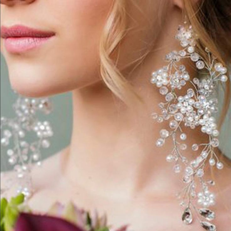 a close up of a woman wearing earrings with flowers on the back of her head