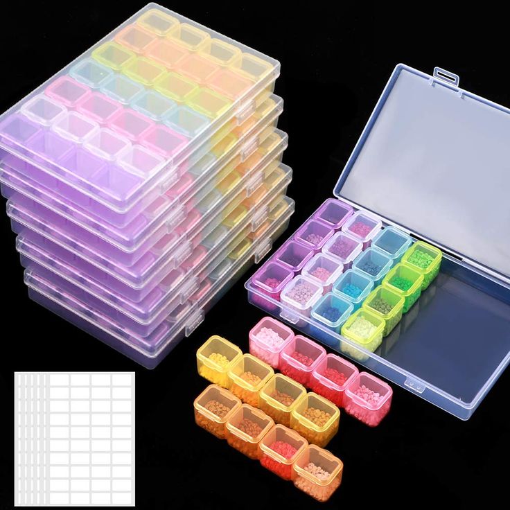 there are many different colored trays on the table and one is filled with small plastic containers