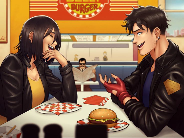 two people sitting at a table in front of a burger