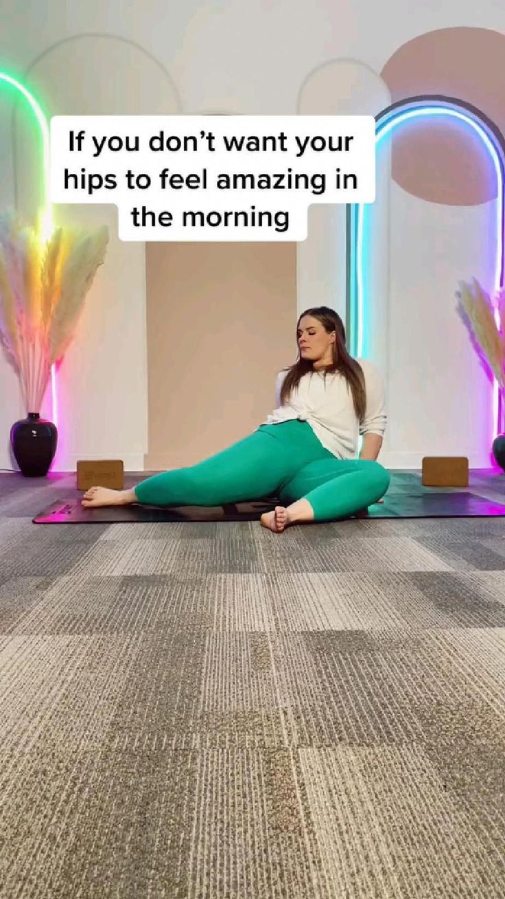 a woman is sitting on the floor with her legs crossed and looking up at something