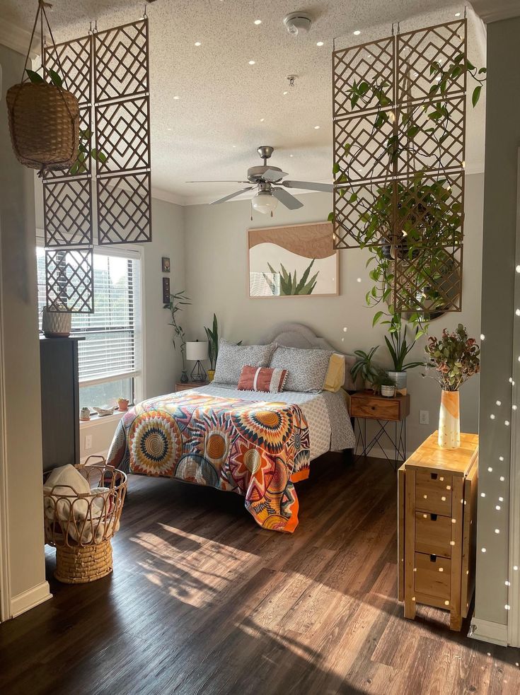 a bedroom with a bed, dresser and plant on the wall in front of it