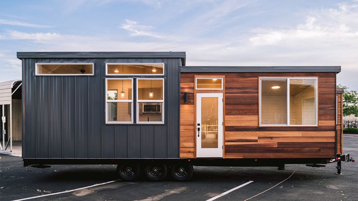 a tiny house on wheels parked in a parking lot