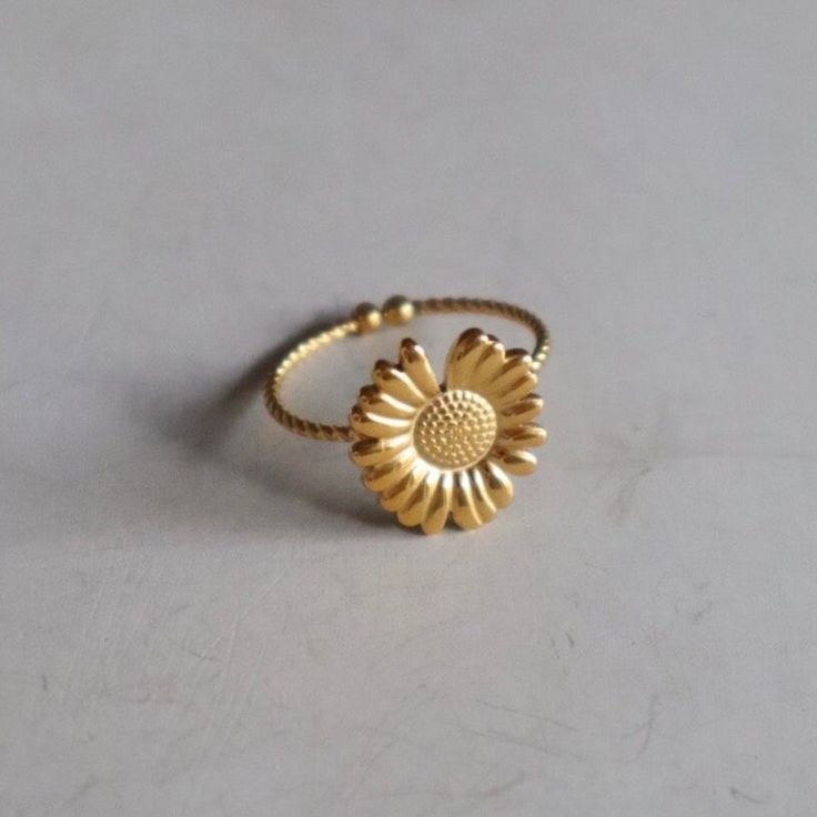 Discover our ring with a delicate sunflower - an enchanting accessory that underlines your style with natural elegance. Made in the elegant color gold and adjustable, it is made of high-quality stainless steel. Opt for customizable elegance and a fresh touch with this special ring. Spring Gift Gold Jewelry, Adjustable Gold Flower Ring, Dainty Adjustable Jewelry For Spring, Adjustable Gold Brass Flower Ring, Adjustable Gold Flower Ring In Brass, Dainty Adjustable Spring Jewelry, Dainty Gold Flower Stackable Rings, Adjustable Dainty Spring Jewelry, Delicate Gold Flower Ring For Spring