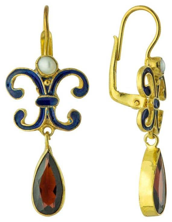 Looking at this earrings is a visual feast. Enamel work was revived in Renaissance jewelry. Here, arabesques enameled royal blue, crowned by a cultured pearl, swing a garnet pendant. 24k gold over sterling silver. European backs for pierced ears. Size:1 1/2 inches. Elegant Gemstone Earrings With Enamel, Elegant Enamel Earrings With Gemstones, Elegant Enamel Dangle Jewelry, Elegant Hallmarked Enamel Jewelry, Elegant Enamel Drop Earrings Jewelry, Elegant Enamel Drop Earrings, Gold Earrings With Historical Design For Gift, Elegant Enamel Dangle Earrings, Gold Historical Design Earrings For Gift