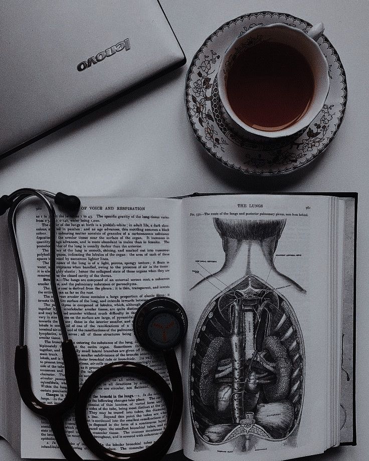 an open book with a stethoscope next to it and a cup of tea