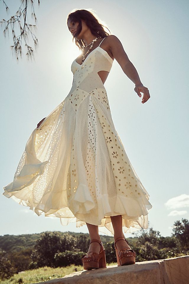 a woman in a white dress is standing on a ledge