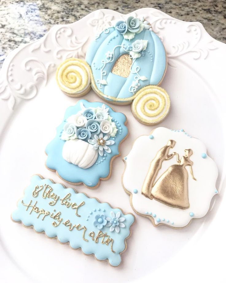 decorated cookies on a white plate with blue and gold decorations for baby's first birthday