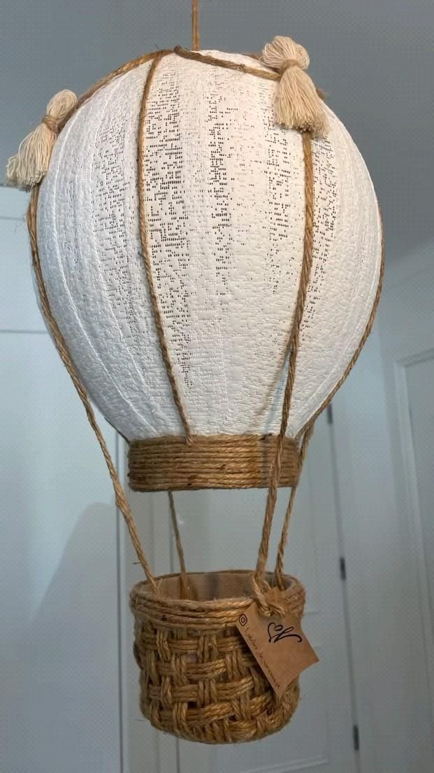 a white hot air balloon with writing on it hanging from the ceiling in a room