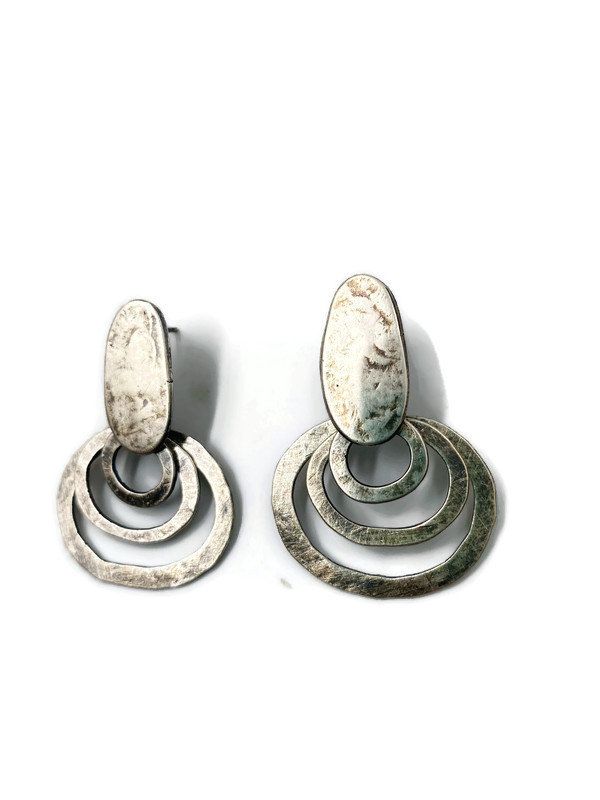 "Hand fabricated sterling silver earrings. These are beautiful, sculptural earrings! The pebble top is a post. They measure 1 1/2\" from top to bottom and are approx. 2\" across the widest part. The concentric loops swing when worn. Oxidised to highlight the surface texture." Elegant Hand Forged Circle Earrings, Contemporary Sterling Silver Jewelry With Oxidized Finish, Contemporary Silver Earrings With Oxidized Finish, Contemporary Oxidized Metal Earrings, Contemporary Hammered Silver Jewelry, Contemporary Hand Forged Metal Earrings, Modern Metal Earrings With Oxidized Finish, Modern Hammered Open Circle Earrings, Modern Silver Hoop Earrings With Oxidized Finish