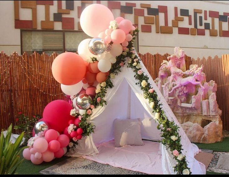 a teepee with balloons and flowers on it