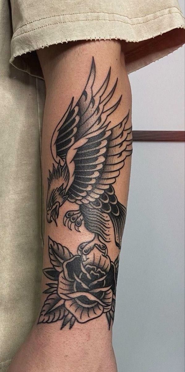 an eagle and rose tattoo on the arm