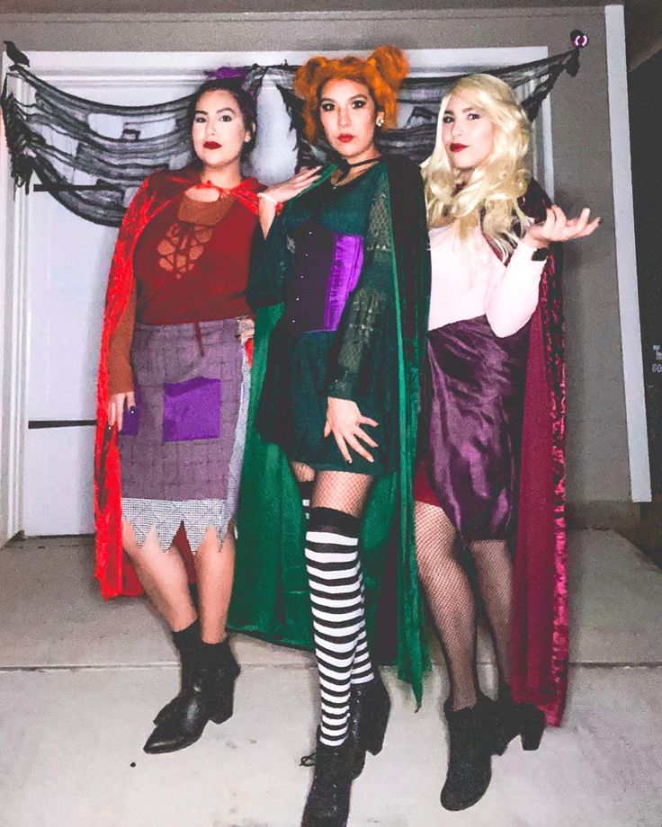 three women dressed in costumes posing for a photo