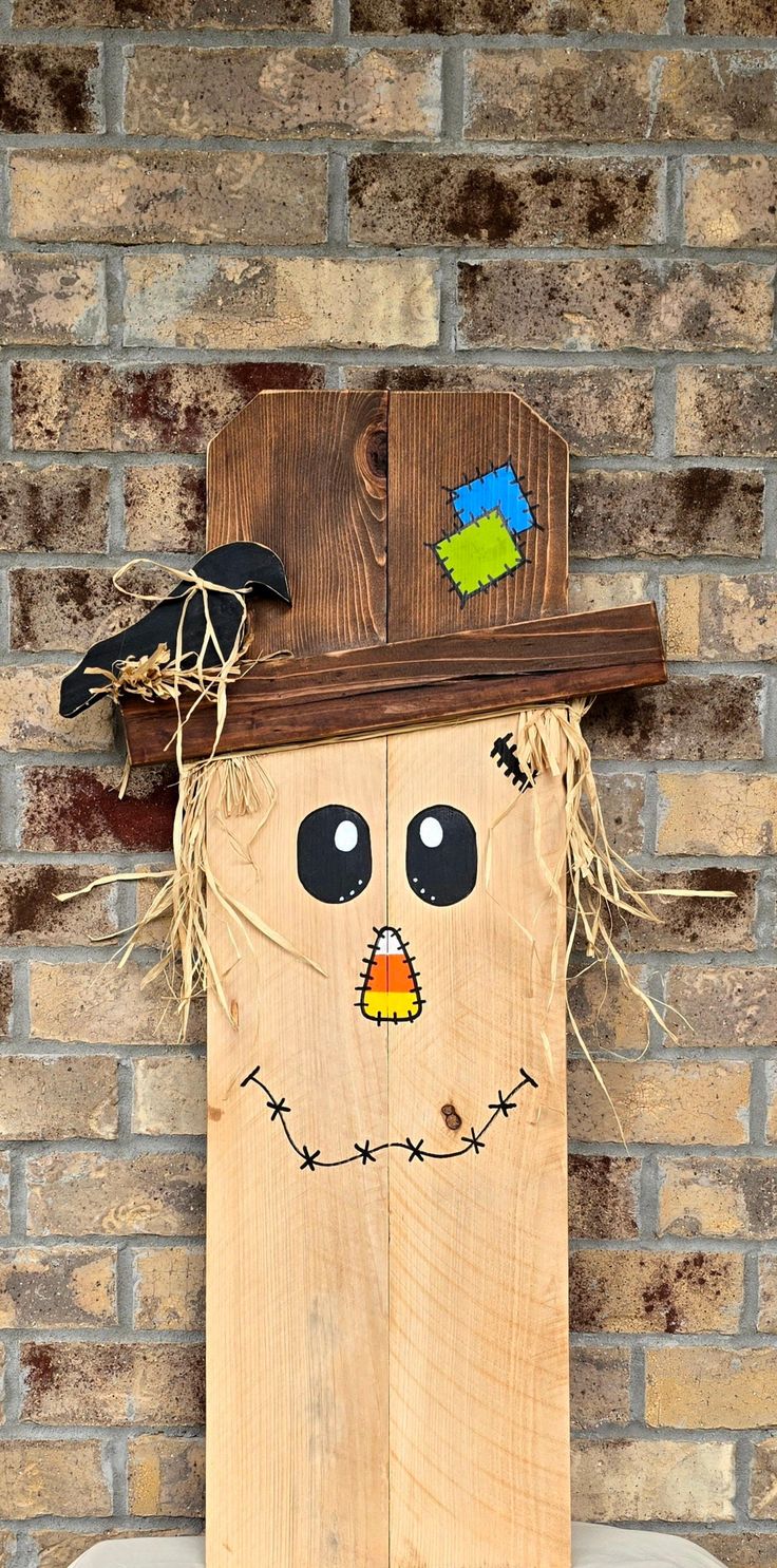 a wooden scarecrow head mounted to the side of a brick wall