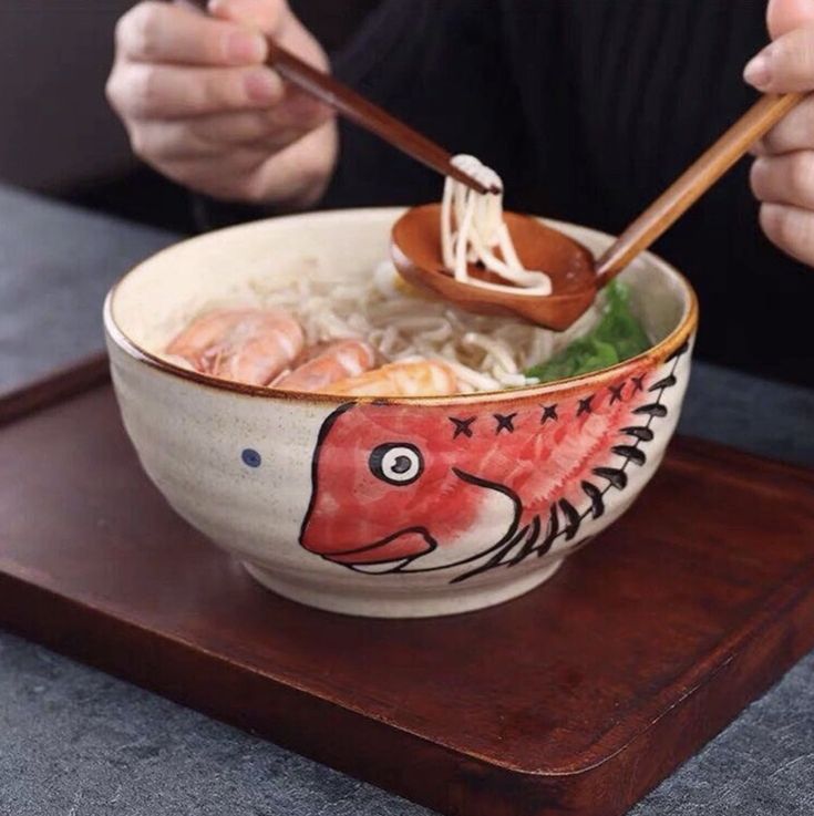 a person eating noodles with chopsticks in a bowl