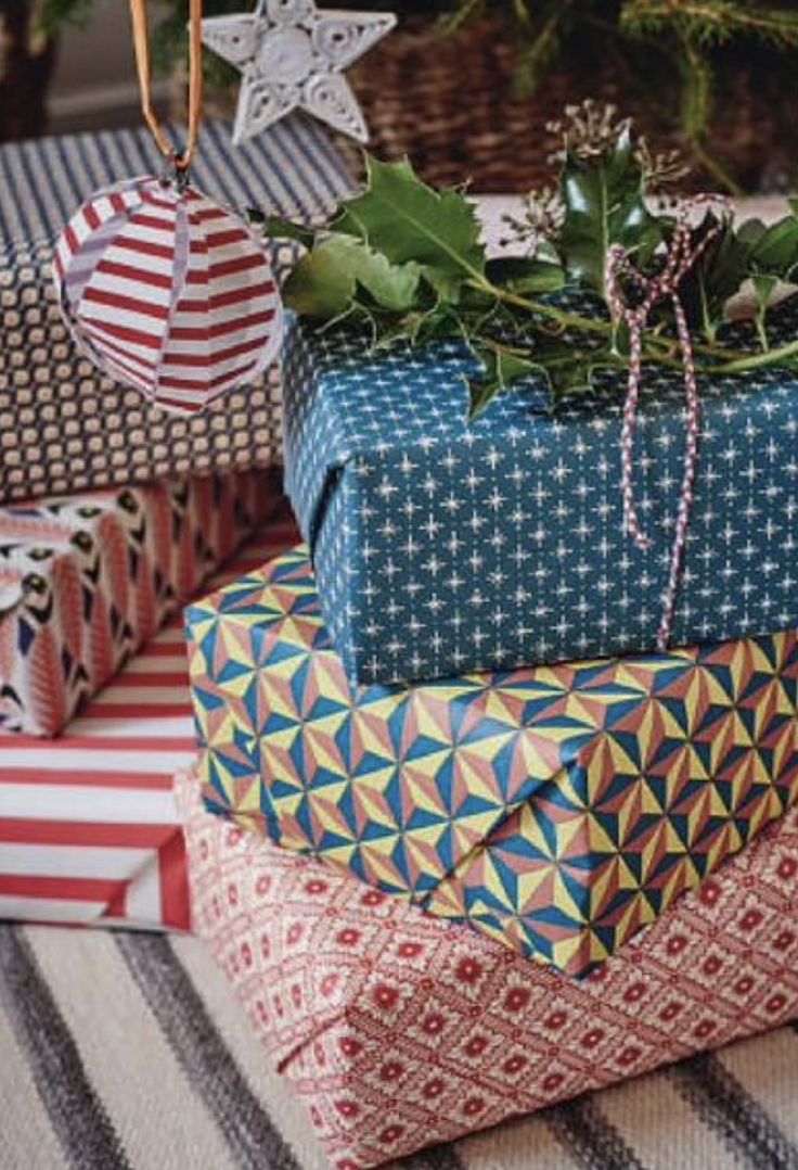 presents stacked on top of each other under a christmas tree