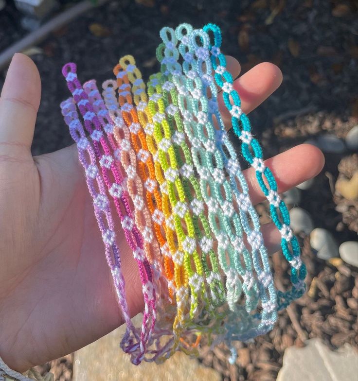 a hand holding several different colored bracelets