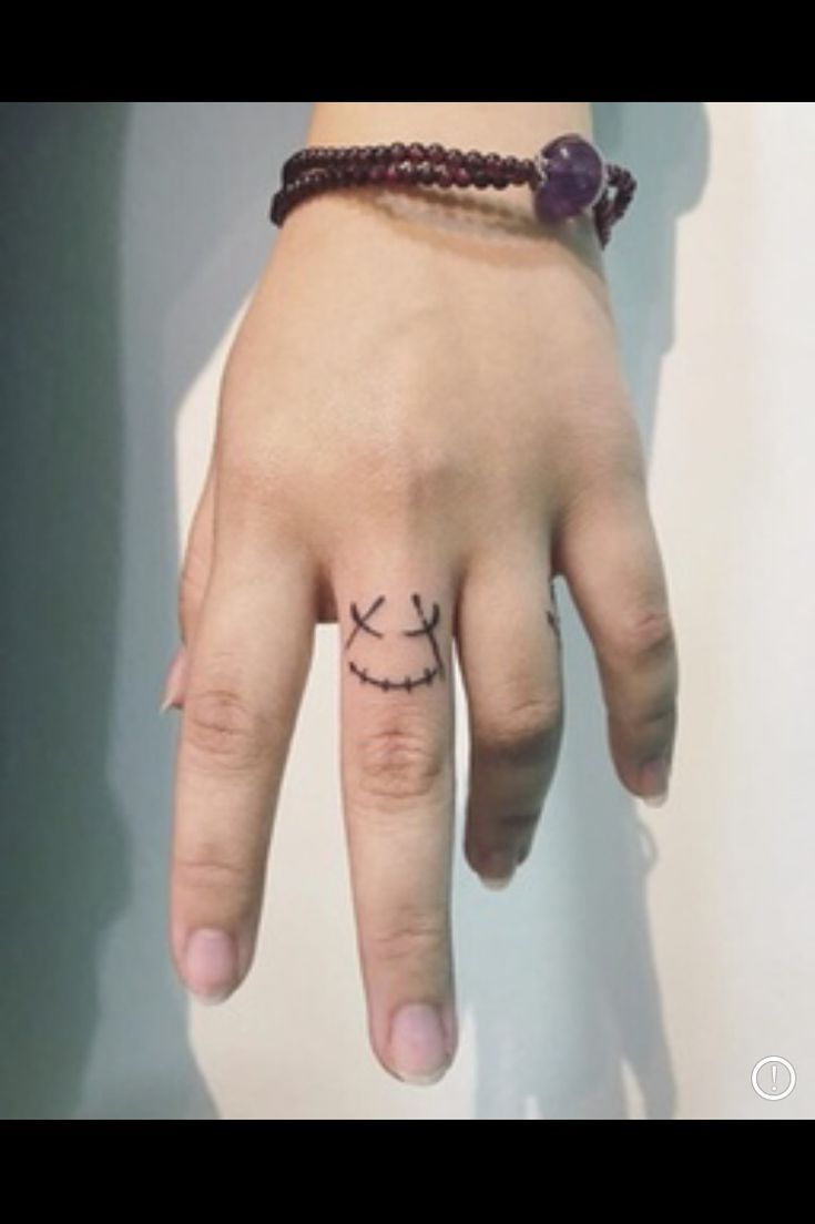 a person's hand with a small tattoo on it