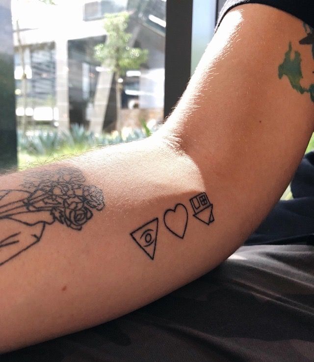 a person's arm with tattoos on it and other things in the background,