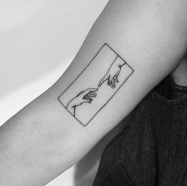 a tattoo on the arm of a person with hands touching each other