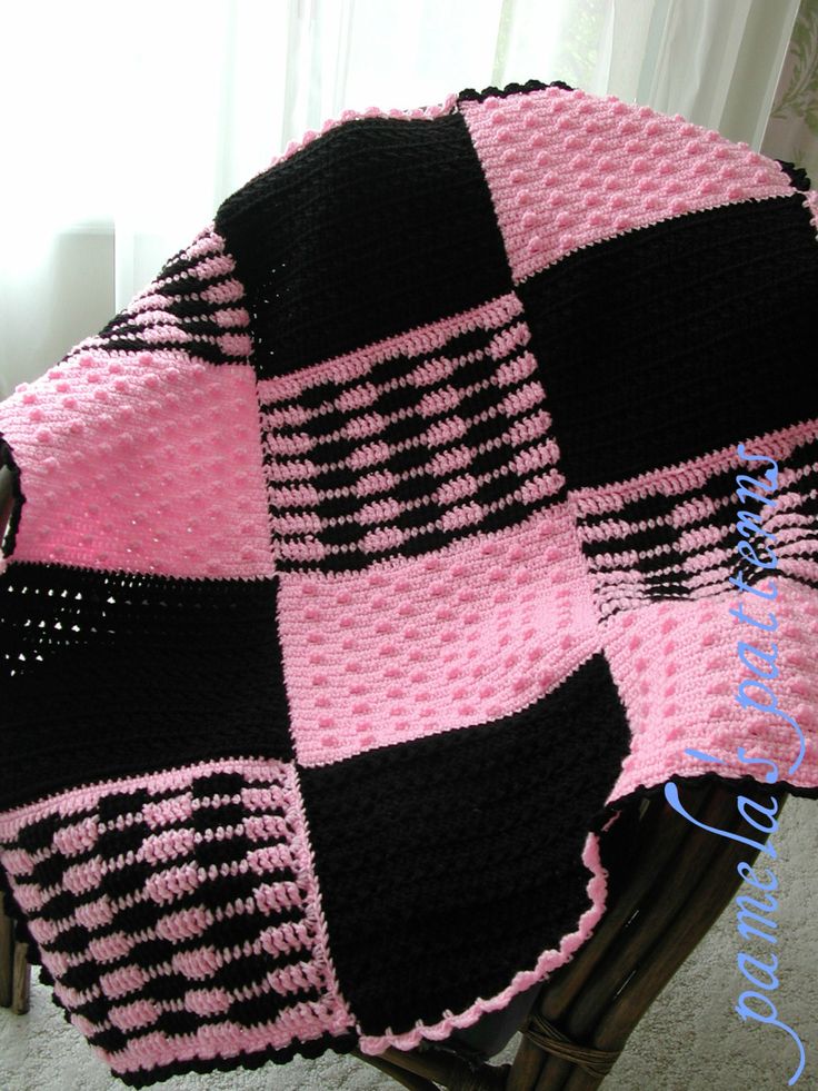 a black and pink blanket sitting on top of a chair