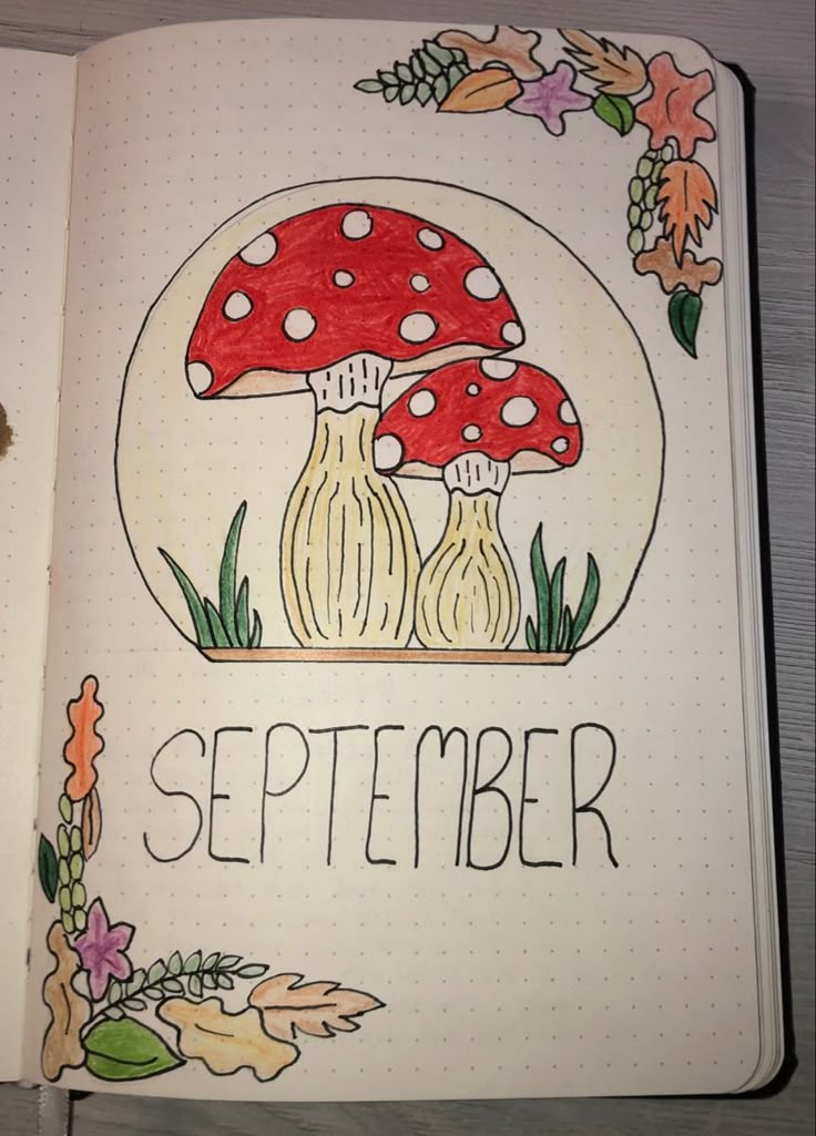 an open notebook with a drawing of two mushrooms and the words september written on it