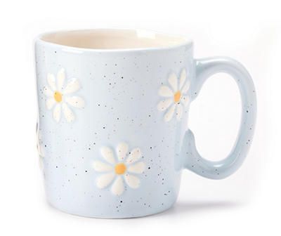 a white and blue coffee cup with yellow flowers on the inside is sitting in front of a white background