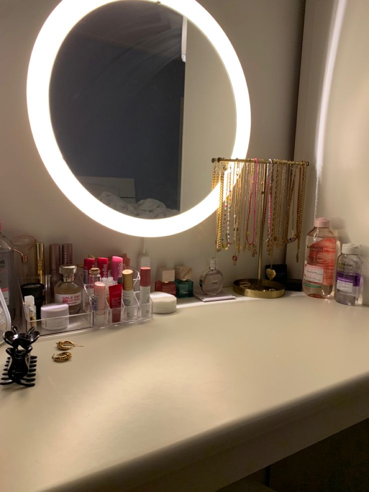 a mirror that is sitting on top of a counter next to bottles and other items