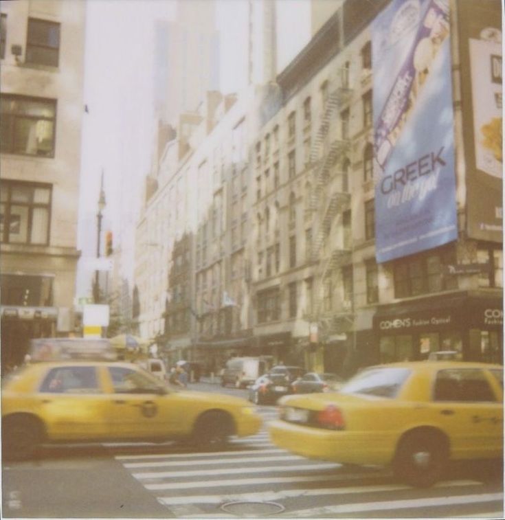 yellow cabs are driving down the street in new york city