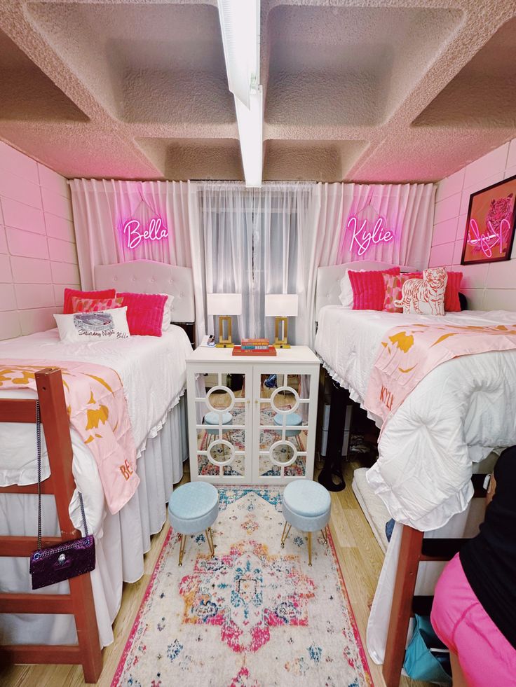 two beds in a small room with pink walls