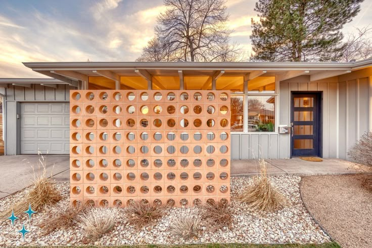 a house with a large perfored wall in front of it's entrance