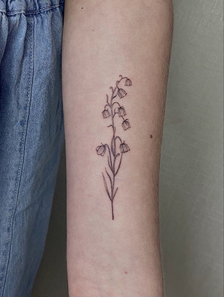 a small flower tattoo on the arm