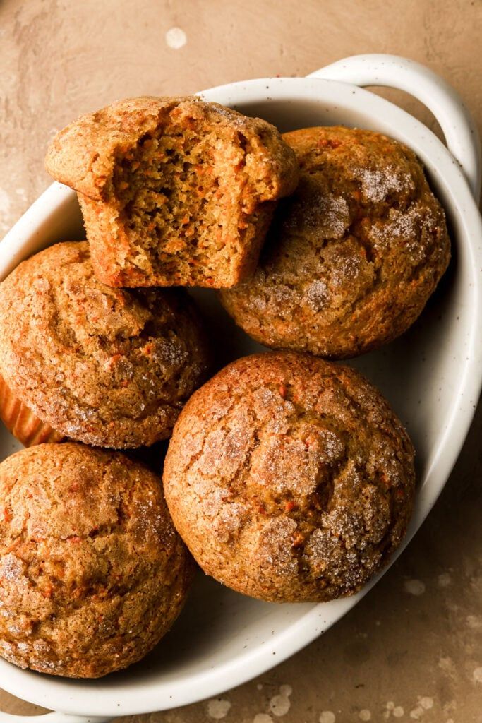 a white bowl filled with muffins on top of a table