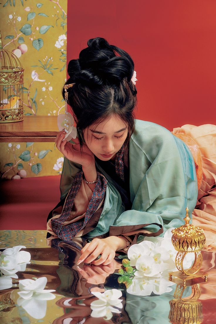 a woman in a kimono is looking at her cell phone while sitting on a bed