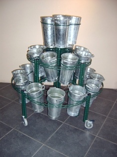 several metal buckets stacked on top of each other in the middle of a room