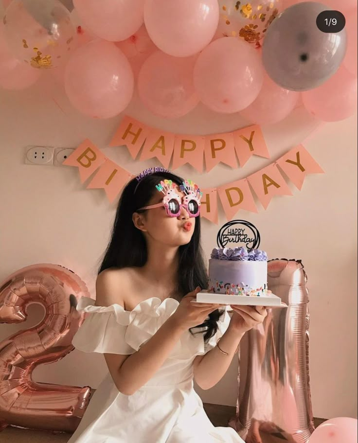 a woman sitting in front of a birthday cake