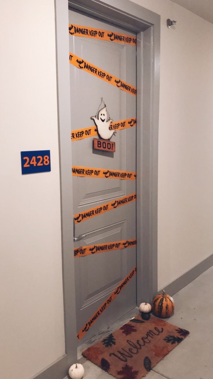 a door decorated with halloween tape and pumpkins