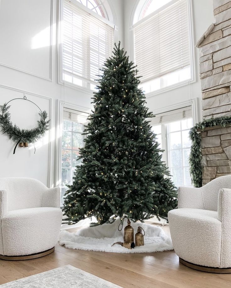 a living room with a christmas tree in the center and two chairs around it on the floor