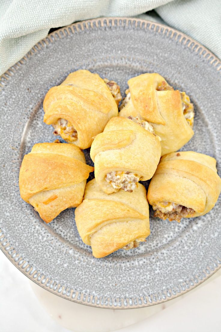 a plate filled with pastries on top of a white table cloth next to a napkin