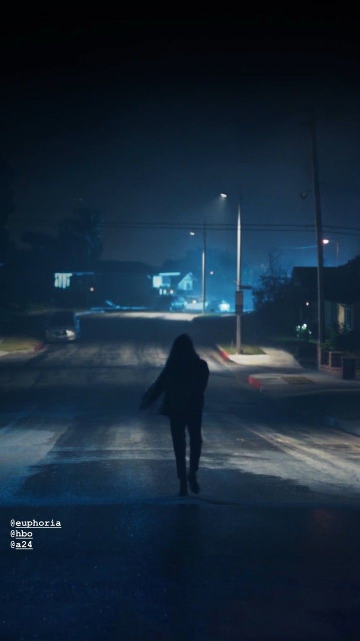 a person walking down the street at night