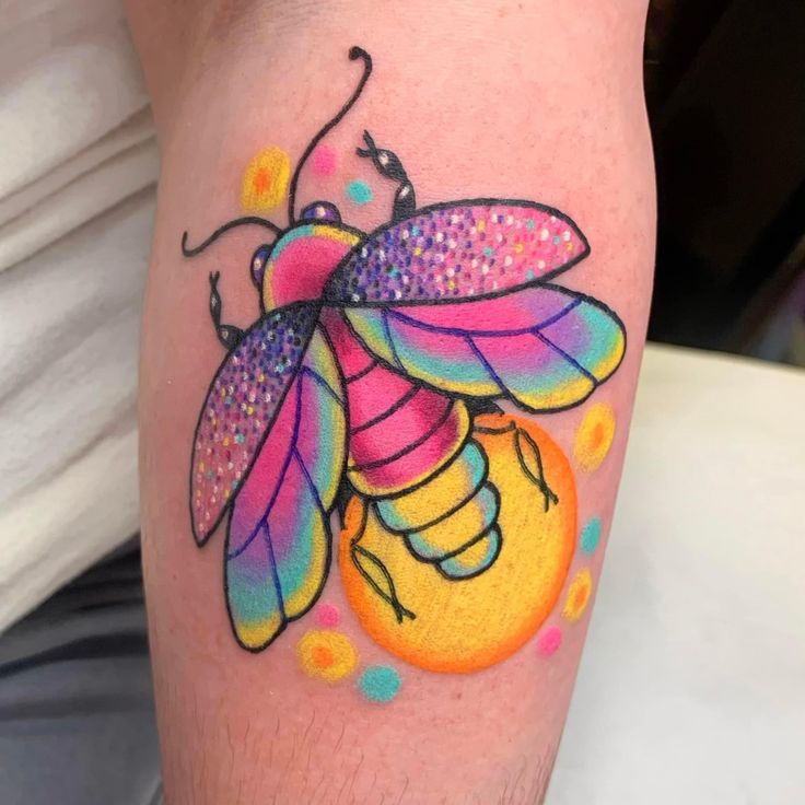 a colorful bee tattoo on the leg